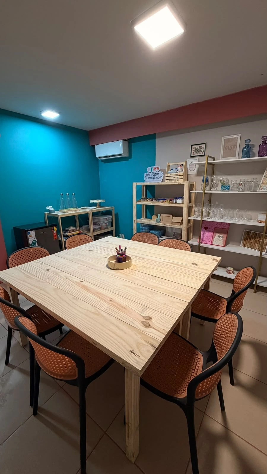 Mesa coletiva do Laboratório da Imaginação cercada de cadeiras